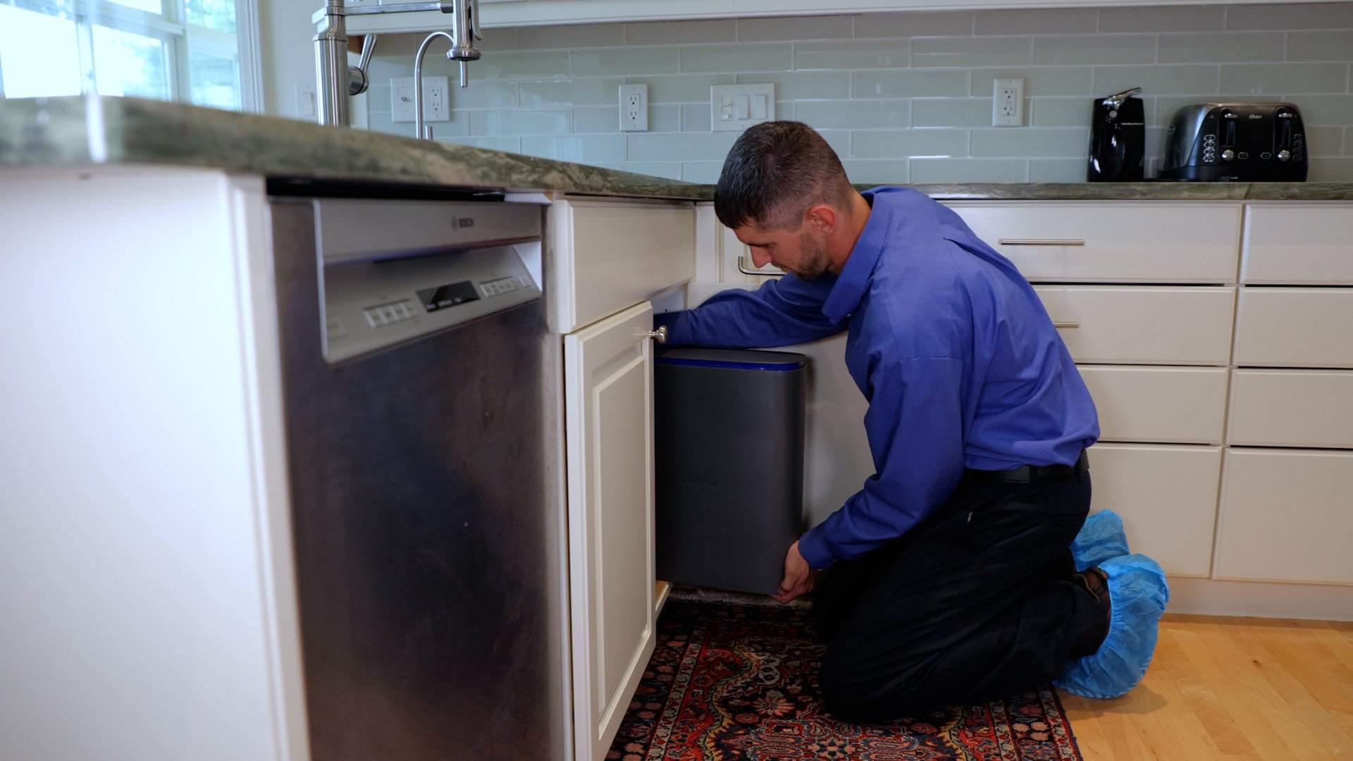 Culligan expert installing drinking water system in kitchen
